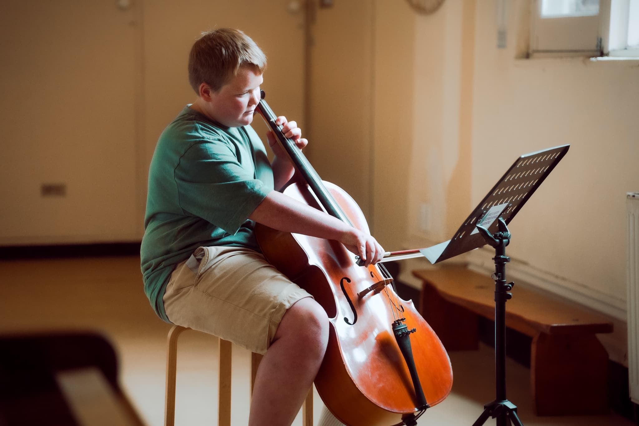 Student playing cello in warm golden light