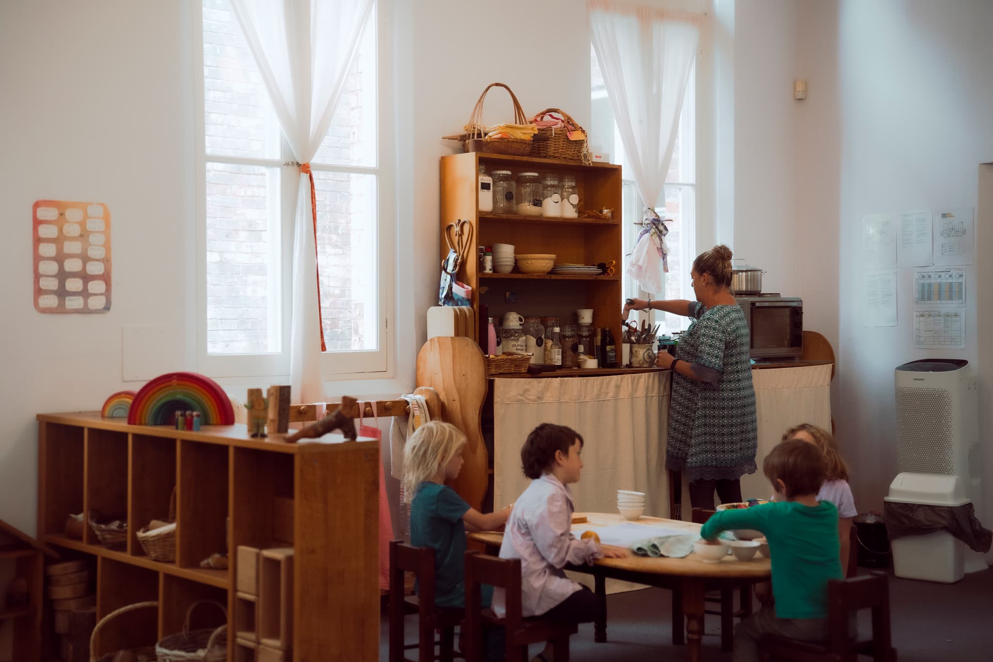 Children sharing snack time with their teacher